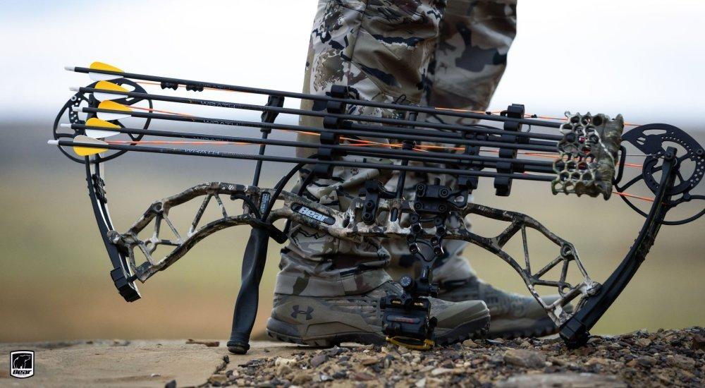 an archery bow resting on a man's leg